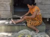 Perempuan Dayak Taboyan meraut rotan di tangga rumah kayu di Desa Baok, Kalimantan Tengah
