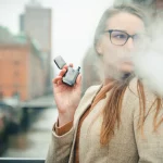 Perempuan menghisap rokok elektrik di luar ruangan