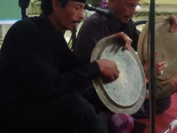 Dua pemain salawat dulang menabuh talam kuningan sambil melagukan syair