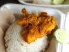 Nasi ayam penyet dengan timun tersaji dalam kotak makanan bawa pulang