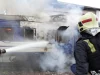 Petugas pemadam kebakaran menyemprotkan air ke gerbong kereta yang terbakar di Volyn