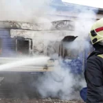 Petugas pemadam kebakaran menyemprotkan air ke gerbong kereta yang terbakar di Volyn