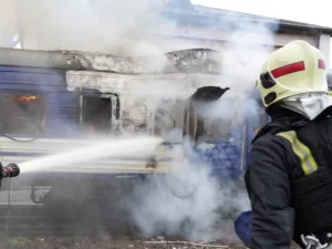 Petugas pemadam kebakaran menyemprotkan air ke gerbong kereta yang terbakar di Volyn