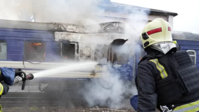 Petugas pemadam kebakaran menyemprotkan air ke gerbong kereta yang terbakar di Volyn