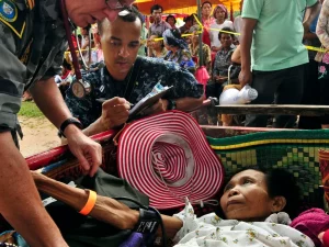 Seorang petugas medis Angkatan Laut Amerika Serikat memeriksa tekanan darah seorang perempuan di Kamboja.