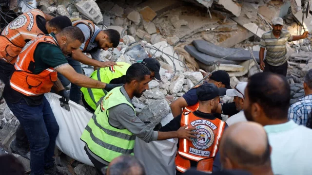 Petugas Pertahanan Sipil Gaza mengevakuasi korban dari reruntuhan gedung di Kota Gaza