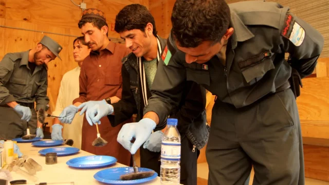 Anggota polisi Afghanistan berlatih menaburkan serbuk sidik jari pada kursus forensik di Paktika, 2013
