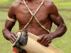 Pria Papua memainkan alat musik pukul tradisional