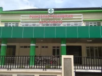 Gedung Puskesmas Pegambiran Kota Padang berdinding hijau dengan pagar besi di depannya