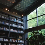 Rak buku bertingkat tinggi berpenerangan hangat di toko buku Tsutaya, Ebetsu, Hokkaido, Jepang