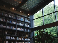 Rak buku bertingkat tinggi berpenerangan hangat di toko buku Tsutaya, Ebetsu, Hokkaido, Jepang