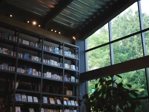 Rak buku bertingkat tinggi berpenerangan hangat di toko buku Tsutaya, Ebetsu, Hokkaido, Jepang