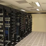 Deretan rak server berisi perangkat jaringan di dalam ruang pusat data