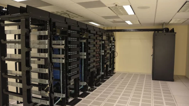 Deretan rak server berisi perangkat jaringan di dalam ruang pusat data