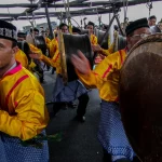 Penabuh berseragam kuning memainkan rapa'i besar dalam pertunjukan Rapa'i Pasee di Aceh