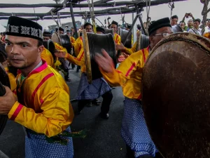 Penabuh berseragam kuning memainkan rapa'i besar dalam pertunjukan Rapa'i Pasee di Aceh