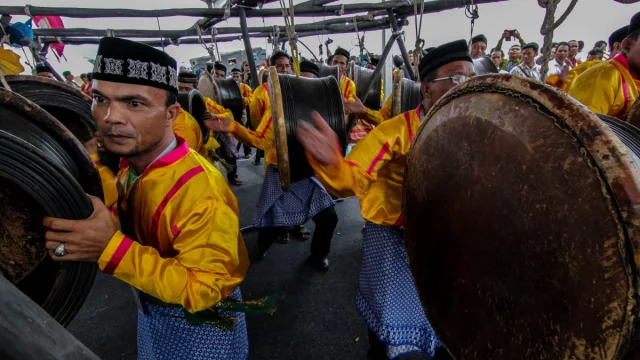 Penabuh berseragam kuning memainkan rapa