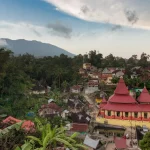 Pemandangan Nagari Tuo Pariangan menjelang senja dengan masjid beratap merah, rumah gadang, dan lereng gunung di latar belakang