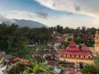 Pemandangan Nagari Tuo Pariangan menjelang senja dengan masjid beratap merah, rumah gadang, dan lereng gunung di latar belakang