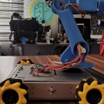 Robot beroda mekanum berlengan di atas meja kerja laboratorium