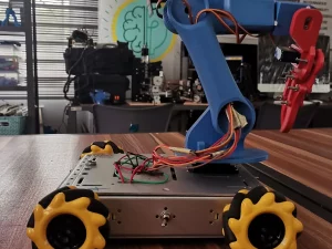 Robot beroda mekanum berlengan di atas meja kerja laboratorium