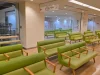 Ruang tunggu rumah sakit yang lengang dengan deretan sofa hijau di Shibuya, Tokyo