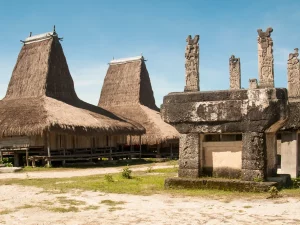 Rumah adat beratap menjulang dan kubur batu megalitik berukir di Kampung Rende, Sumba Timur