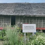 Papan nama Rumah Betang Ensaid Panjang di halaman depan rumah adat itu