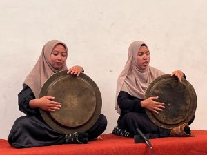 Dua pesalawat perempuan memangku dulang kuningan dalam pertunjukan salawat dulang.