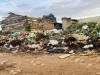 Tumpukan sampah kantong plastik berserakan di tanah dekat rumah bata di Kyenjojo, Uganda