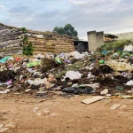 Tumpukan sampah kantong plastik berserakan di tanah dekat rumah bata di Kyenjojo, Uganda
