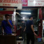 Warung bubur ayam yang melayani pembeli sarapan pada pagi hari di Jakarta