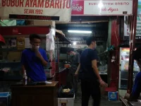 Warung bubur ayam yang melayani pembeli sarapan pada pagi hari di Jakarta