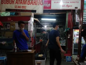 Warung bubur ayam yang melayani pembeli sarapan pada pagi hari di Jakarta