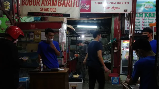 Warung bubur ayam yang melayani pembeli sarapan pada pagi hari di Jakarta