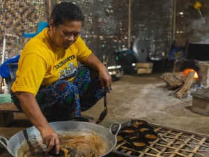 Ilustrasi perajin Indonesia mengolah gula aren dengan cara tradisional di dapur sederhana