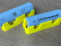 Dua sel baterai litium ion silinder tipe 18650 dan 21700 di atas dudukan