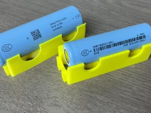 Dua sel baterai litium ion silinder tipe 18650 dan 21700 di atas dudukan
