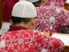Siswa sekolah dasar berseragam batik mengerjakan soal ujian di Jambi
