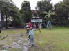 Seorang anak menarik busur panah di lapangan berumput