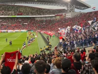 Tribun stadion dipenuhi suporter yang mengibarkan bendera saat pertandingan