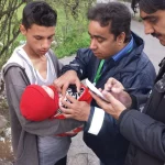 Memeriksa bekas suntikan BCG di lengan bayi, Muzaffarabad, Pakistan