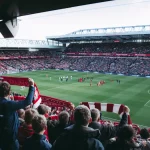 Tribun stadion penuh suporter yang menyambut pemain memasuki lapangan