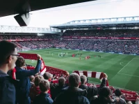 Tribun stadion penuh suporter yang menyambut pemain memasuki lapangan