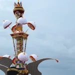 Menara Tabuik berhias payung kertas putih dengan sepasang sayap lebar di bagian bawah dan latar langit