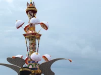 Menara Tabuik berhias payung kertas putih dengan sepasang sayap lebar di bagian bawah dan latar langit