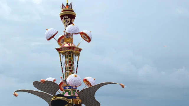 Menara Tabuik berhias payung kertas putih dengan sepasang sayap lebar di bagian bawah dan latar langit