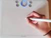 Tangan menggambar menggunakan pena digital di atas tablet grafis.