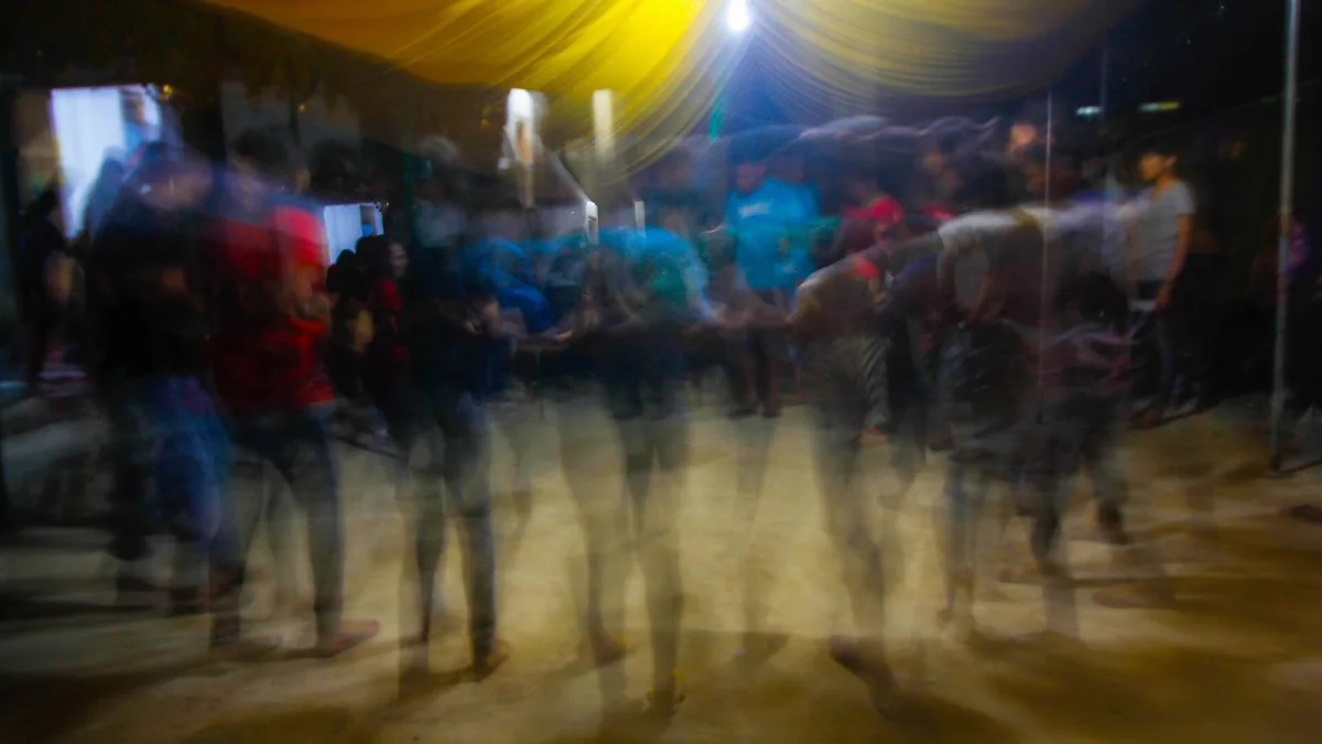 Warga menarikan tari lulo khas Tolaki sambil bergandengan tangan di bawah tenda malam hari