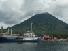 Kapal bersandar di Teluk Jailolo, Halmahera Barat, dengan gunung berselimut awan
